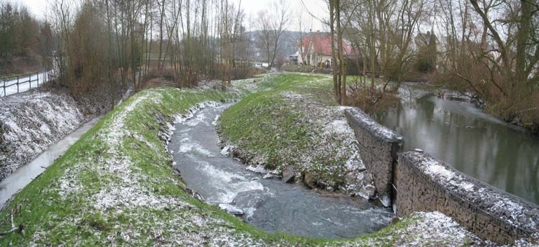Das fertige Umgehungsgerinne an der Aar im ersten Winter, begrünte Böschungen mit leichtem Schnee